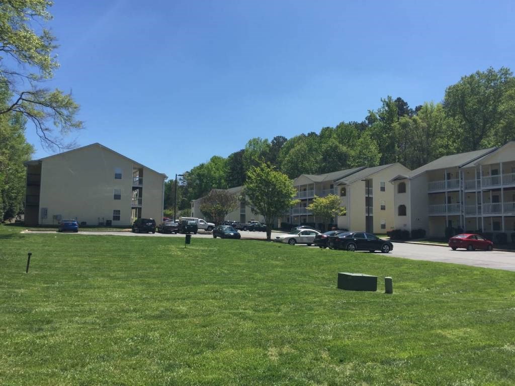 a green lawn in front of an apartment building