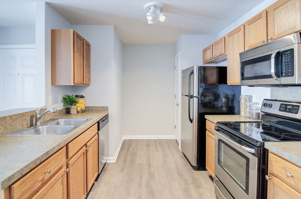 a kitchen with wood cabinets and stainless steel appliances at Enclave at West Ashley Apartments, Charleston, SC, 29414