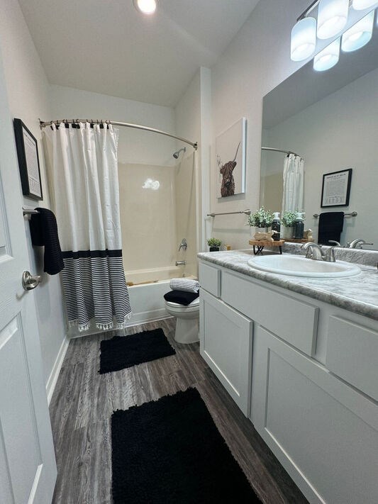 A bathroom with a toilet, sink, and shower.