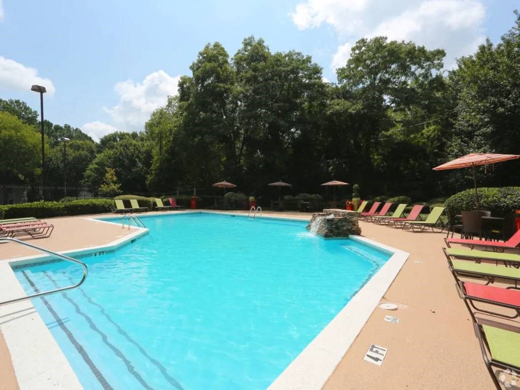a swimming pool with chairs and umbrellas at a resort