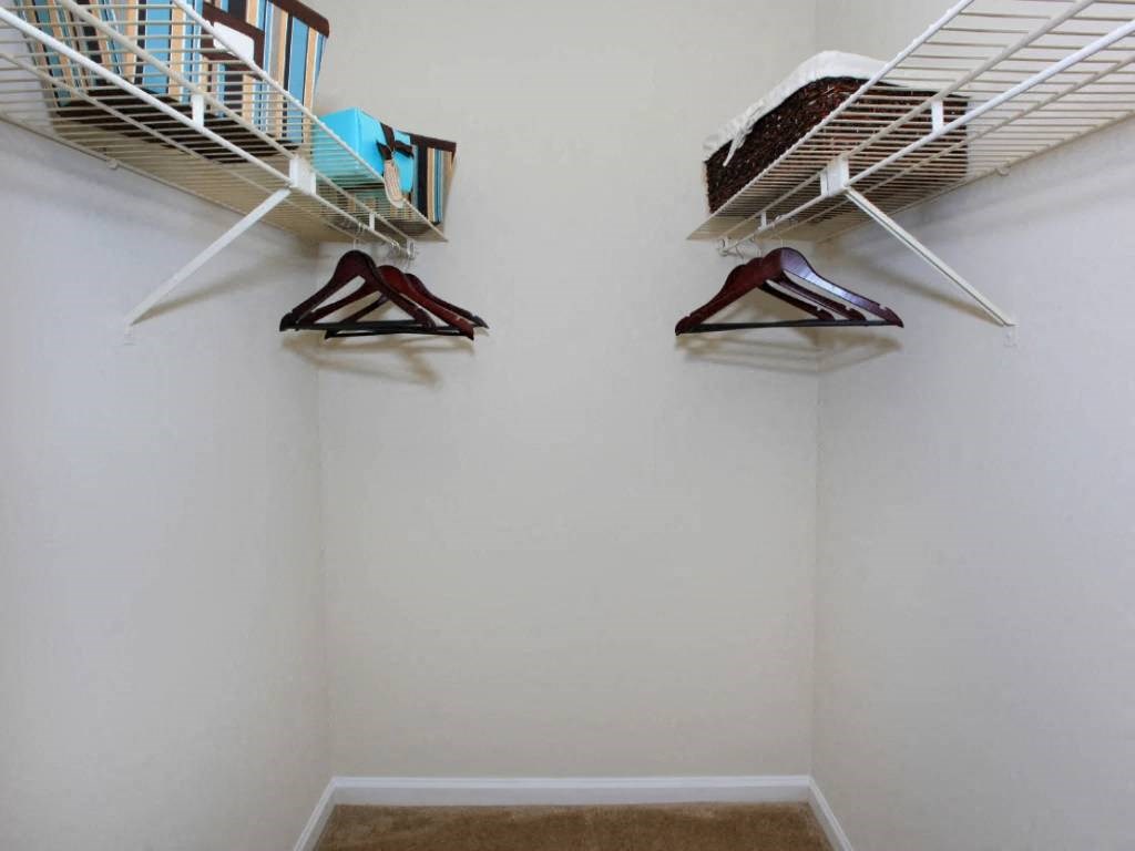 two closets in a white closet with clothes rack