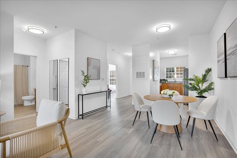 A modern living room with a dining table and chairs.