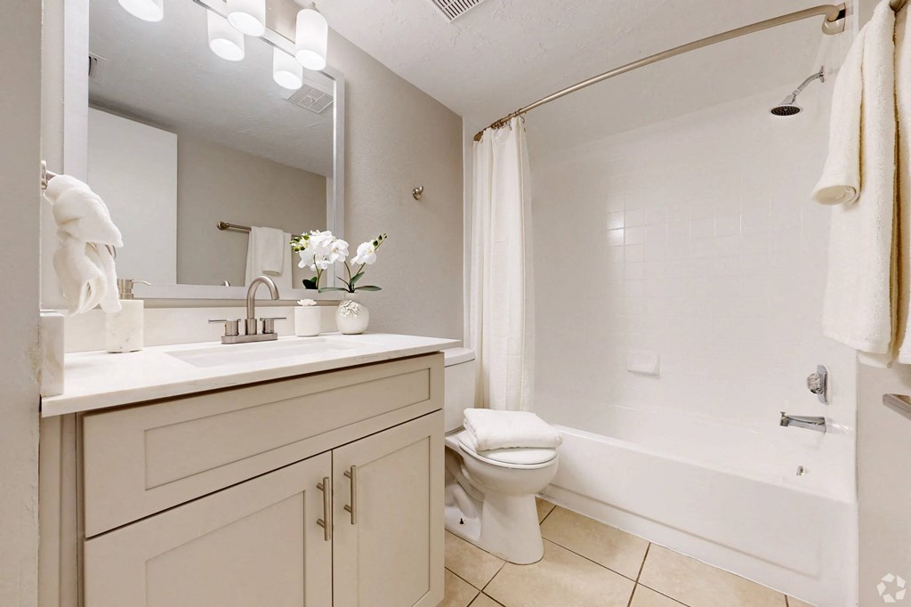 A white bathroom with a toilet, sink, and bathtub.