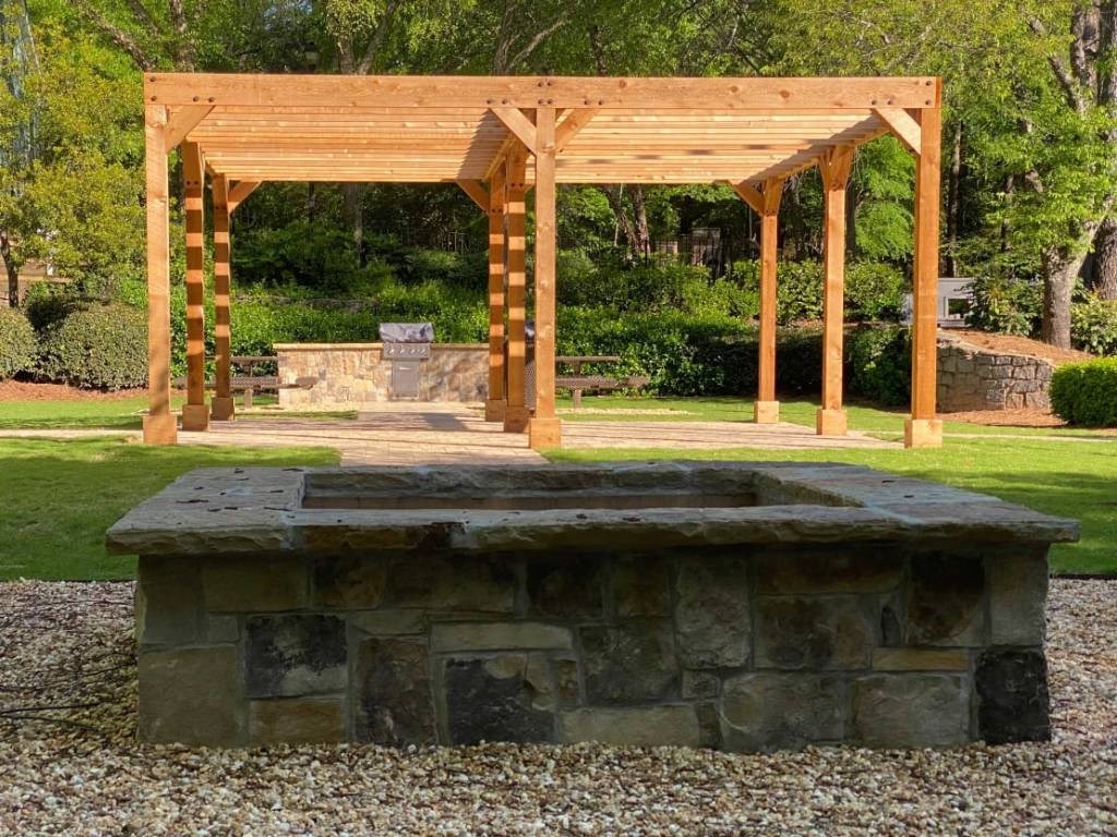 a fire pit with a wooden structure in a park