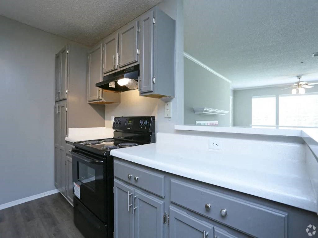 a kitchen with white cabinets and a black stove