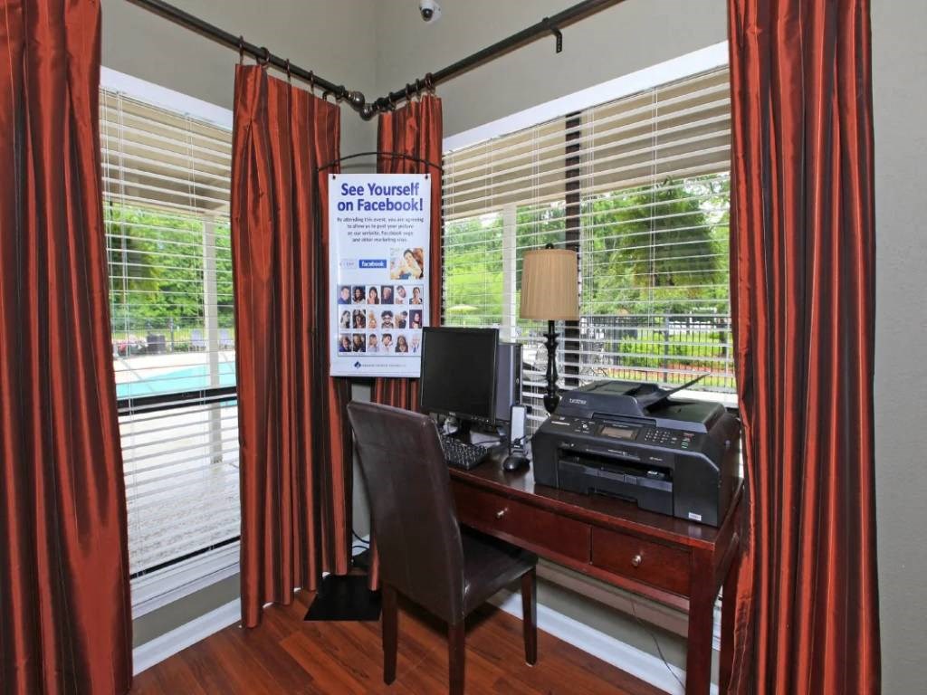 a home office with a desk and a computer in front of a window