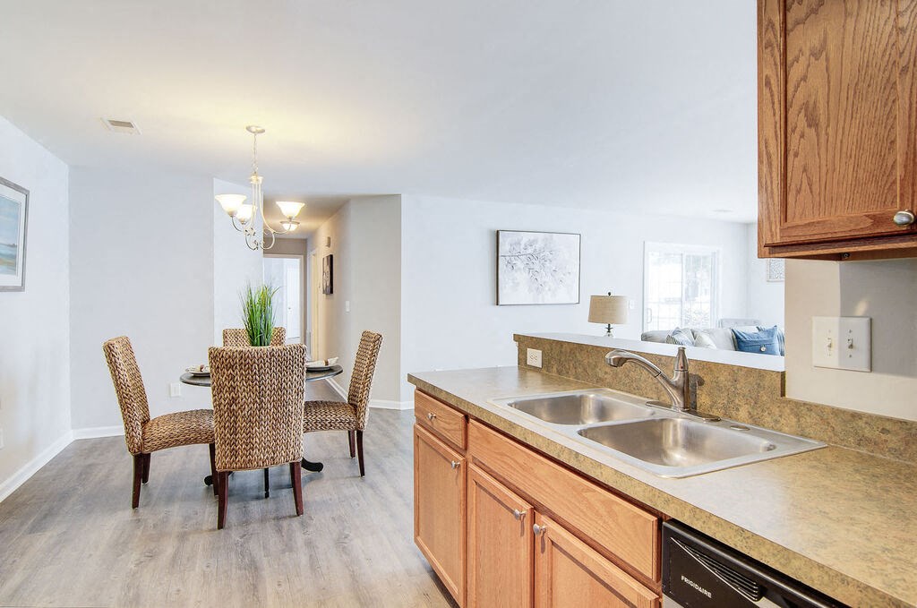 a kitchen with wooden cabinets and a stainless steel sink at Enclave at West Ashley Apartments, Charleston,SC