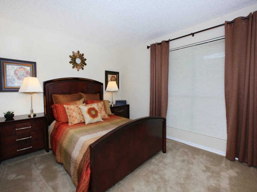 a bedroom with a bed and a window with curtains