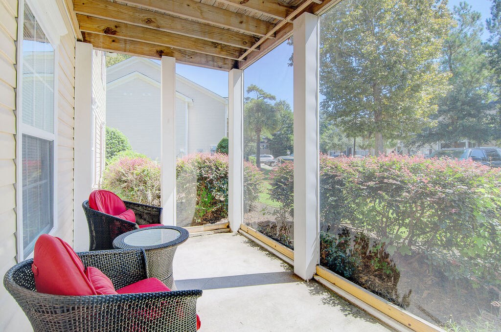 a screened in porch with wicker chairs and a table at Enclave at West Ashley Apartments, Charleston, SC, 29414
