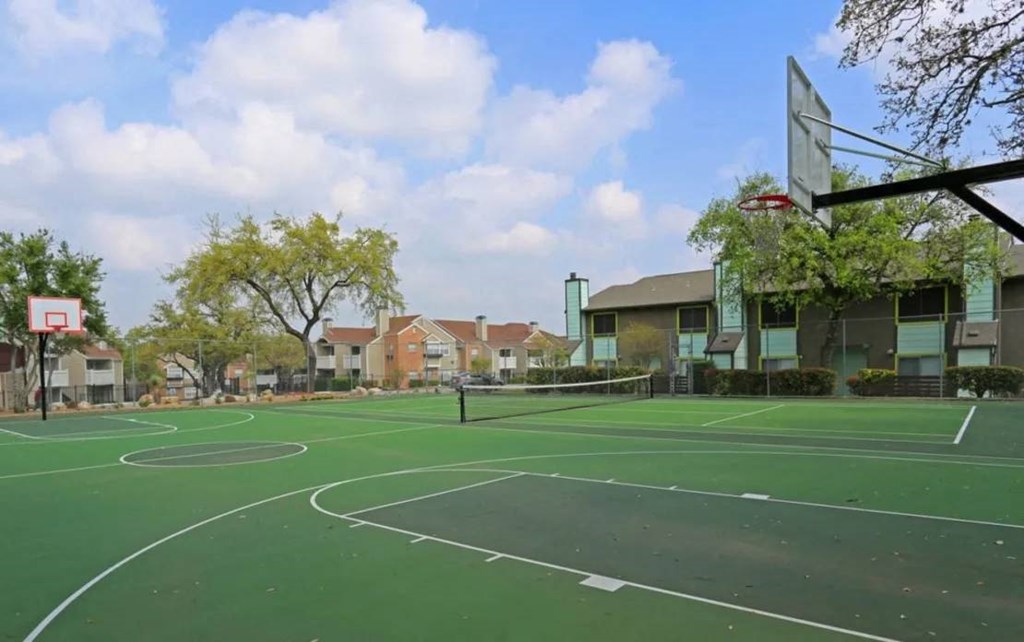 a basketball court with houses in the background at Elevate at Huebner Grove, Texas