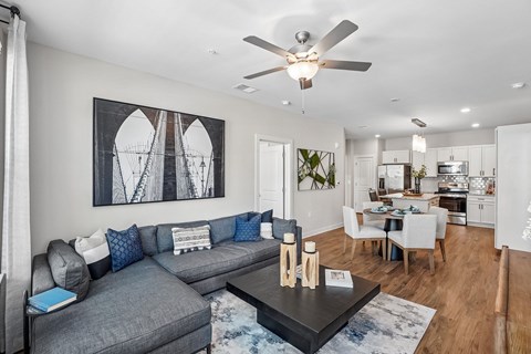 A modern living room with a grey sofa and a large abstract painting on the wall.