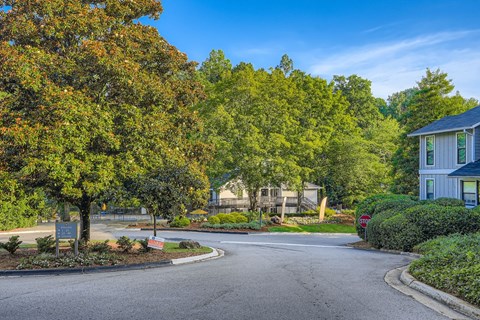 A residential street with houses and trees on both sides.