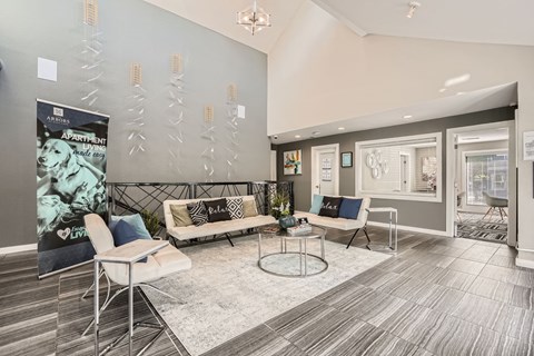 A living room with a couch, chairs, and a poster on the wall.