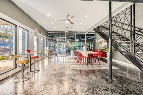 A spacious interior with a staircase, bar stools, and a dining table.