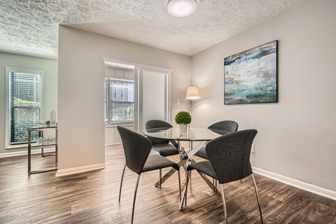 A dining room with a table and chairs.