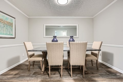 A dining room with a table and chairs.