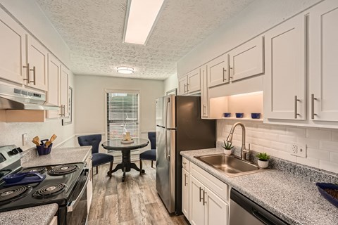 A kitchen with a stove, refrigerator, and sink.