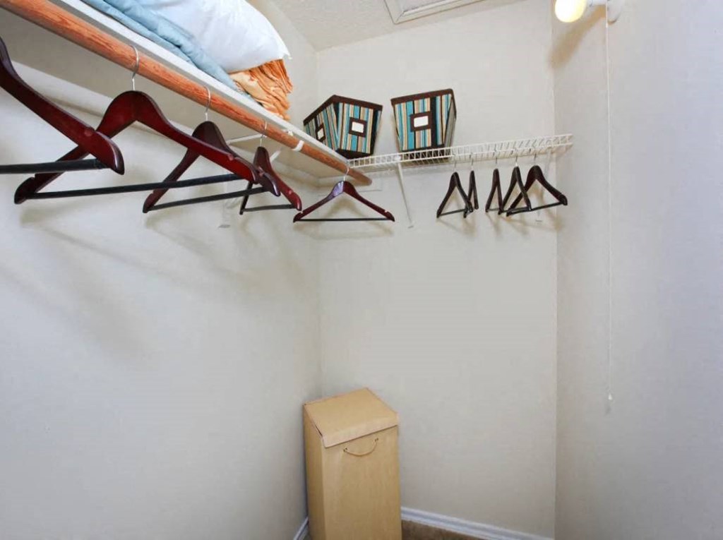 a room with a shoe rack on the wall and a trash can