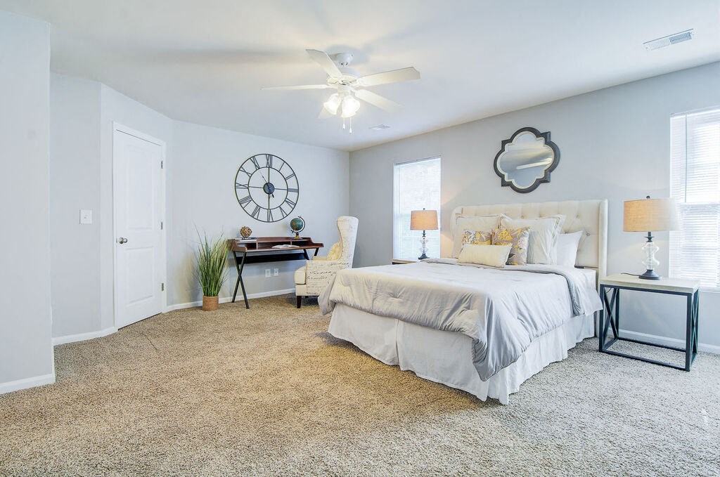 a bedroom with a large clock on the wall at Enclave at West Ashley Apartments, Charleston,32304