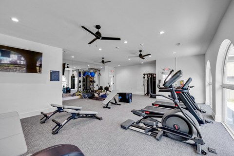 A spacious gym with treadmills, exercise bikes, and other equipment at Crescent Place Apartments, Savannah
