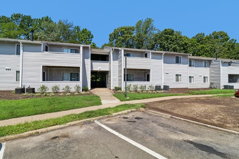 A row of modern townhouses with a clear blue sky above.