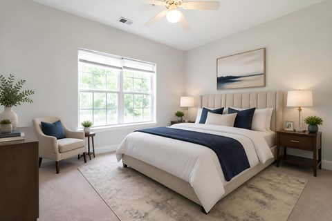 A bedroom with a large bed and a ceiling fan.
