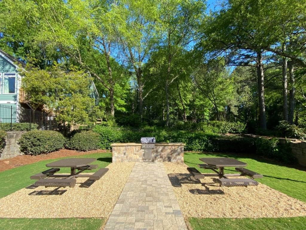 a courtyard with picnic tables and a fire pit