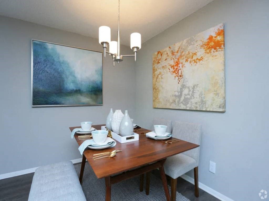 a dining room with a wooden table and chairs
