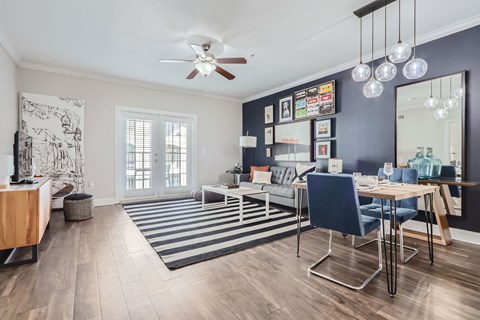 A living room with a ceiling fan and a striped rug.