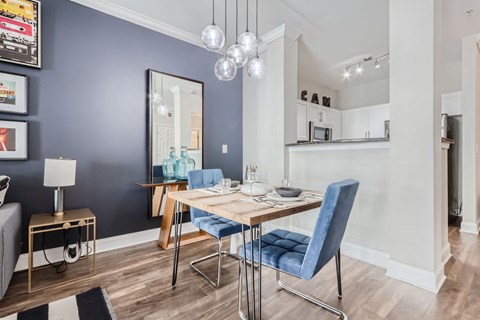 A dining room with a blue chair and a wooden table.