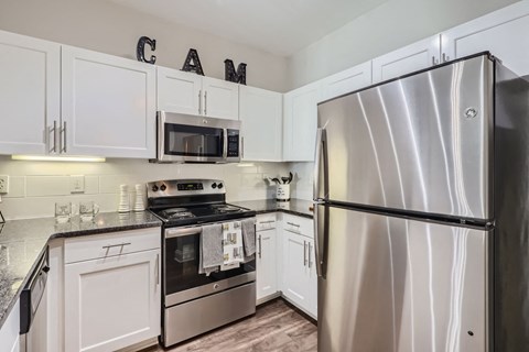 A kitchen with a stove, microwave, and refrigerator.
