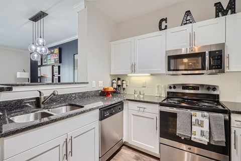 A kitchen with white cabinets and a black stove top oven.