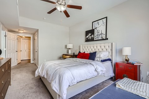 A bedroom with a large bed and a ceiling fan.