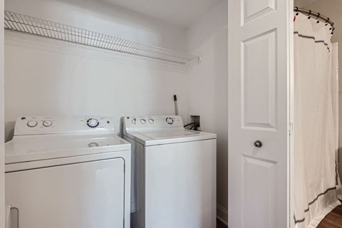 Two white washing machines in a laundry room.