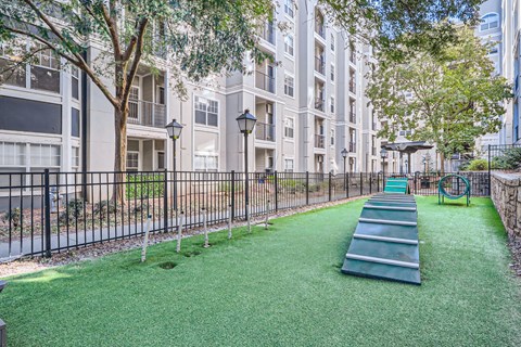 A playground with a slide and a green lawn.