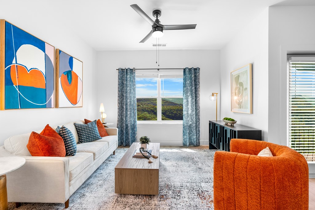 A living room with a white couch, a coffee table, and a ceiling fan.