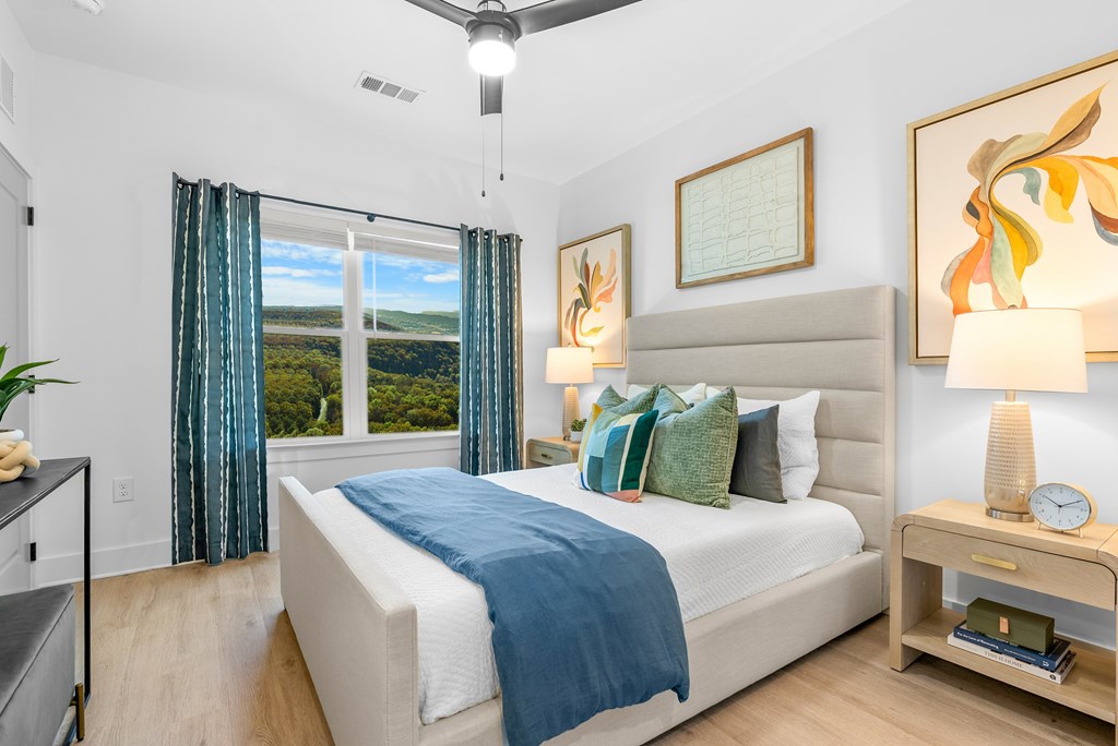 A bedroom with a large bed and a ceiling fan.