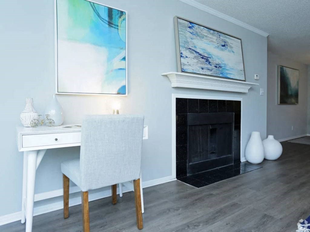 a living room with a fireplace and a desk with a chair