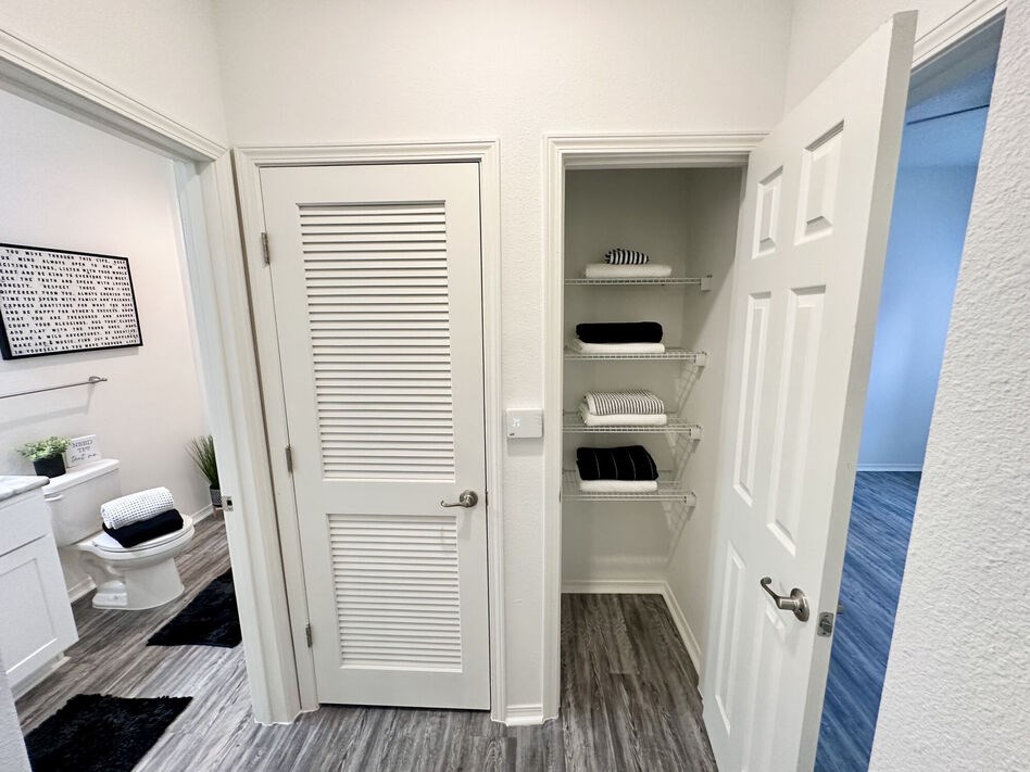 A white bathroom with a white toilet and a white cabinet with a white door.