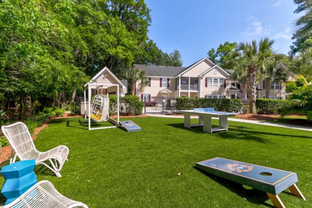 a backyard with a ping pong table and a swing set at Enclave at West Ashley Apartments, Charleston, SC, 29414