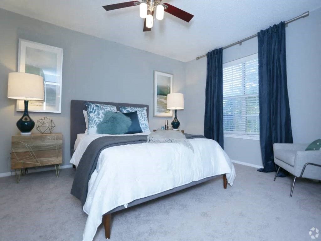 a bedroom with a bed and a ceiling fan
