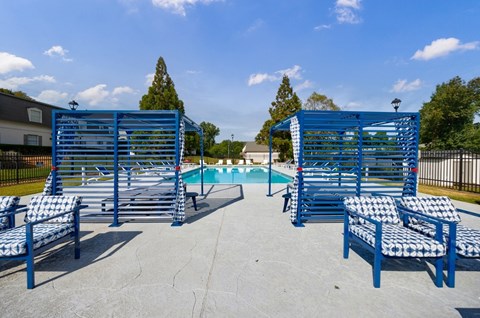 A pool area with blue chairs and a pool.
