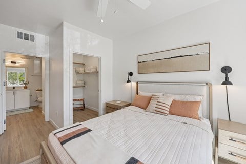 A bedroom with a large bed and a painting on the wall.