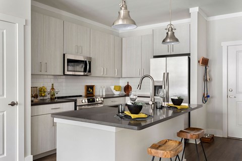 a kitchen with white cabinets and a black counter top