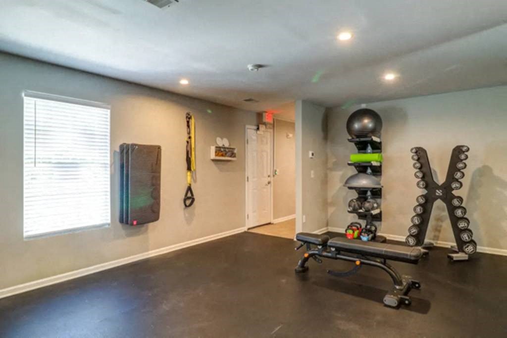 a home gym with a bench and weights at Enclave at West Ashley Apartments, Charleston,32304
