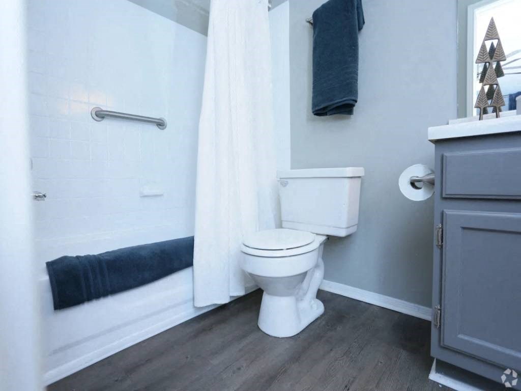 a bathroom with a toilet and a shower curtain