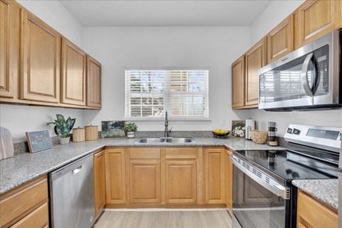 A kitchen with wooden cabinets and a granite countertop.
