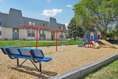 A playground with a blue bench and a slide.