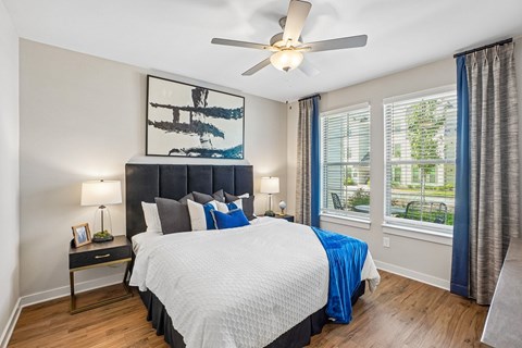 A bedroom with a large bed and a ceiling fan.