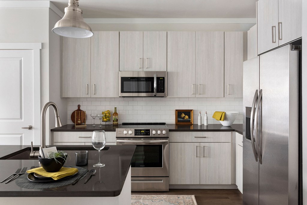 a modern kitchen with white cabinets and stainless steel appliances at The Cannon, Murfreesboro Tennessee